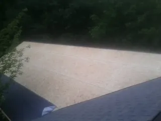 New OSB roof sheathing installed beside an existing shingle roof in Kathleen