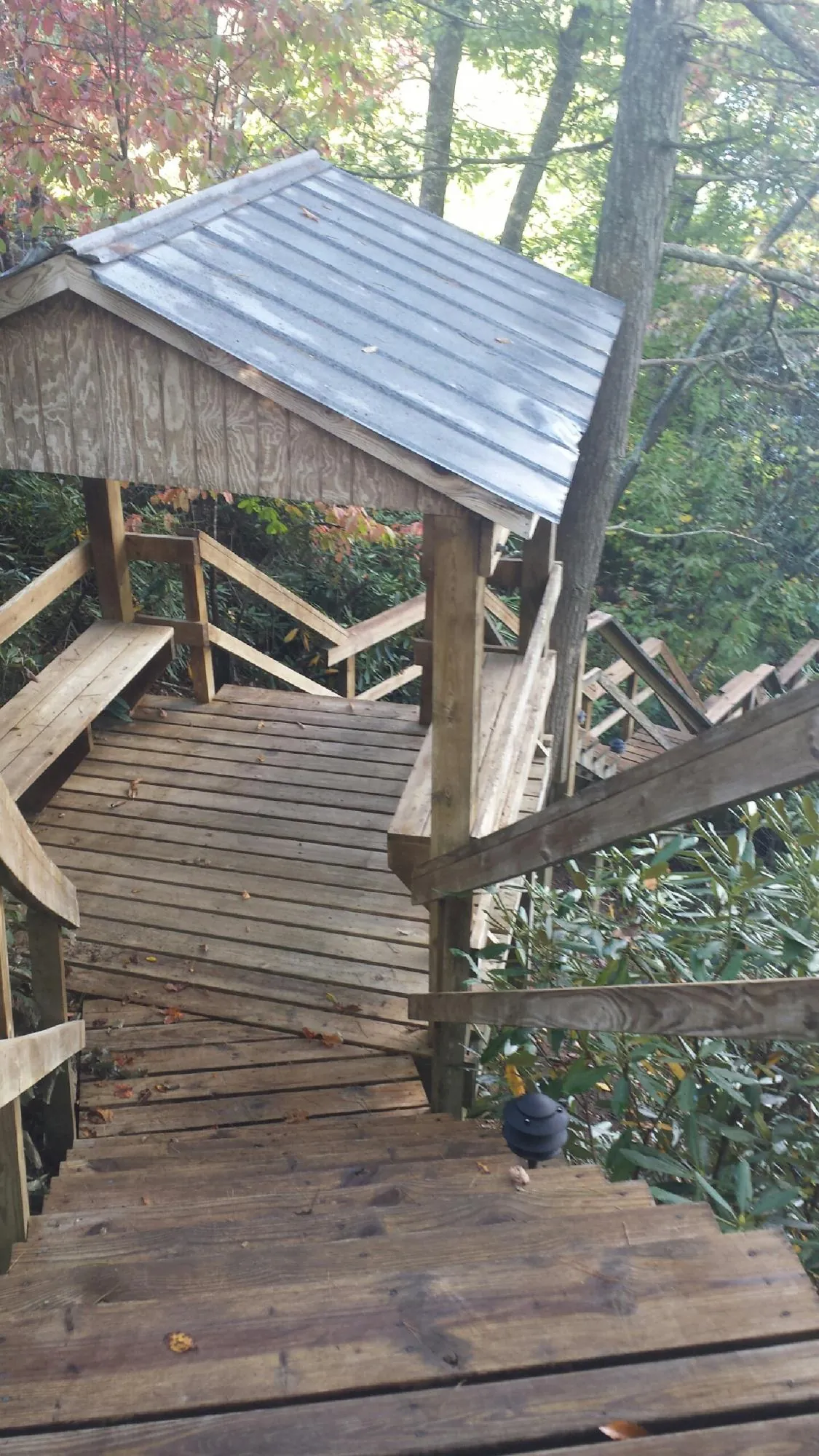 Metal roofed shelter over wooden steps on a wooded walkway — Skylight Repair & Installation work by our crew in Kathleen