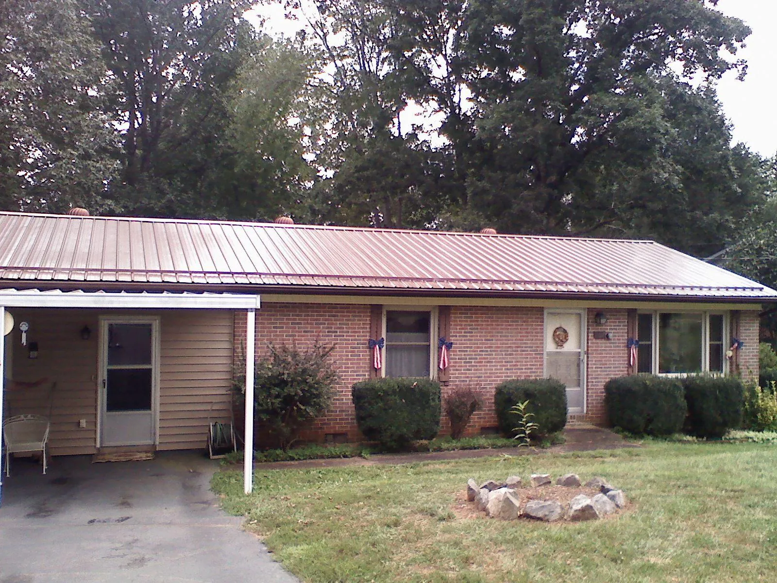 Bronze metal roof and carport on a brick ranch home — Roof Repair work by our crew in Kathleen